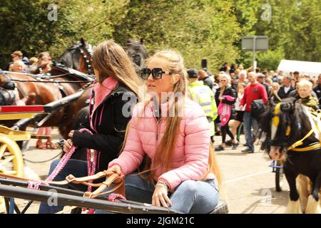 Two young traveller girls riding in a horse and trap. Appleby Horse Fair, Appleby in Westmorland, Cumbria, England, United Kingdom Stock Photo