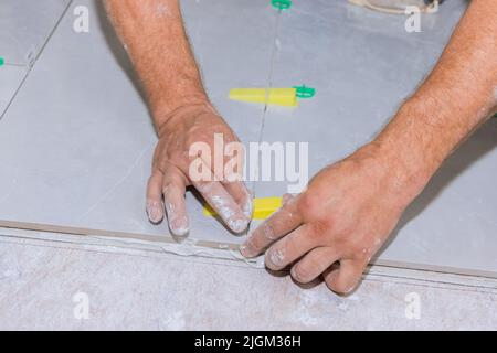 In the construction of a bathroom, a tile leveling system using plastic clips and wedges is used Stock Photo