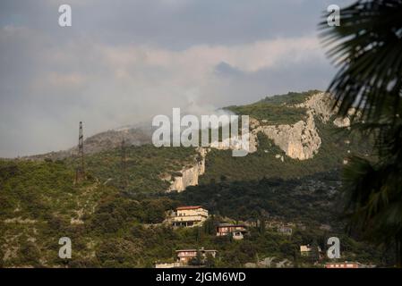Nago, Trentino Alto-Adige, Italy. 11th July, 2022. Smoke rises from the wood during the second day of fires on July 11, 2022 in Nago, Italy. Over 5 hectares of woodland burnt since a fire broke out on July 10, 2022 in Nago, a town located above the lake Garda, in northern Italy, as drought and high temperatures continue all over the country. (Credit Image: © Aleksander Kalka/ZUMA Press Wire) Stock Photo