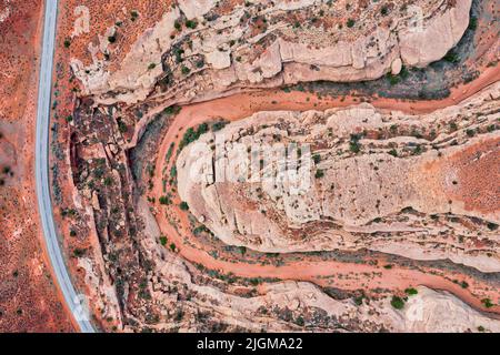 Top down drone photo of highway in Utah through red canyon and empty riverbed.  Stock Photo