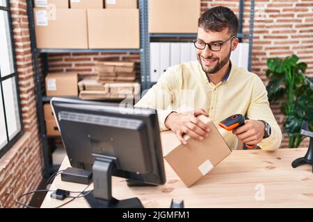 Young hispanic man ecommerce business worker scanning label using barcode reader at office Stock Photo