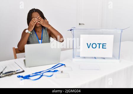 Young african american woman working at political election sitting by ballot rubbing eyes for fatigue and headache, sleepy and tired expression. visio Stock Photo