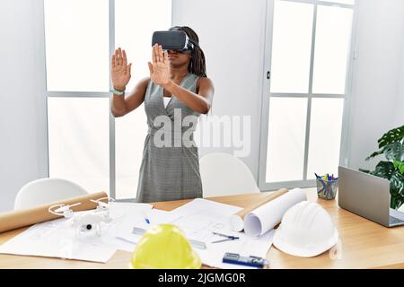 Young african american woman architect using virtual reality glasses at architecture studio Stock Photo