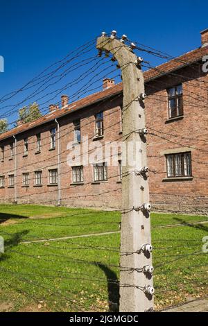 Barb wire electric fence and building inside the Auschwitz I former Nazi Concentration Camp, Auschwitz, Poland. Stock Photo