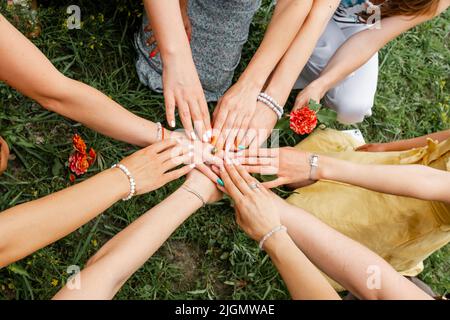 Female models joining hands in a circle. Teamwork Stock Photo