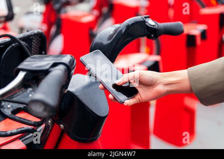 hand with a smart phone unlocking a rental bike Stock Photo