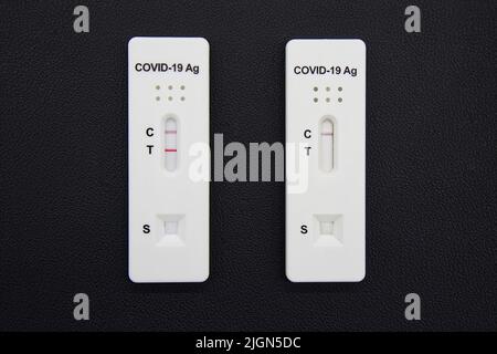 Positive and negative test result of Covid-19 antigen test kits isolated on black background. Coronavirus protective concept Stock Photo