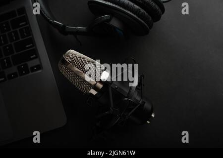 Professional equipment for the home office of a musician, sound engineer, journalist, blogger. Studio microphone, studio headphones, laptop on a gray Stock Photo