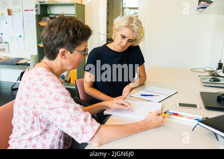 Tilburg, Netherlands. Mature adult woman having a coaching interview while searching for a new job and occupation. Stock Photo