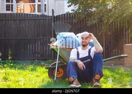 Man resting on the grass after cleaning the garden. Close up, Stock Photo