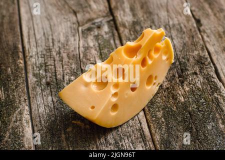 Slice of fresh cheese on old wooden background Stock Photo