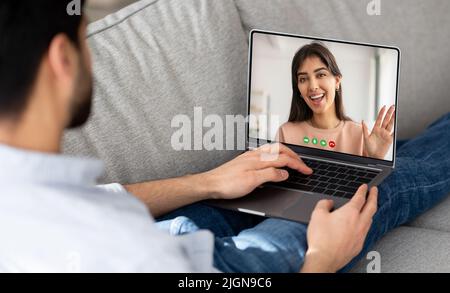Online Meeting. Young man using laptop for video call with his girlfriend Stock Photo