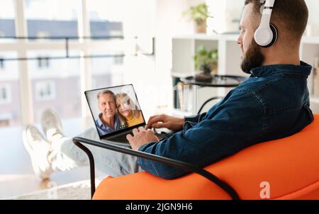 Online Call. Millennial Man Using Laptop For Virtual Call To Senior Parents Stock Photo
