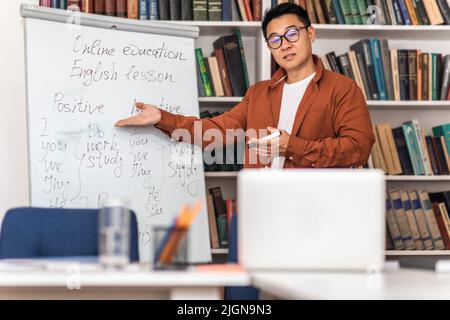 Asian Teacher Teaching Online Having Remote Class Standing At Workplace Stock Photo