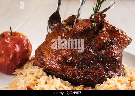 Baked pork ham with stewed cabbage and apple Stock Photo