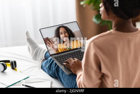 Online Tutoring Concept. Black Woman Using Laptop For Virtual Lesson With Tutor Stock Photo