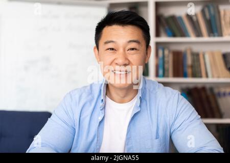 Portrait Of Asian Teacher Man Posing Near Whiteboard In Classroom Stock Photo