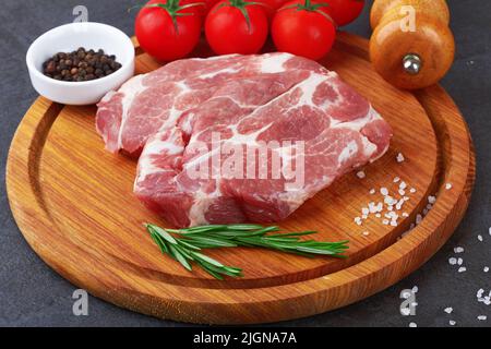 Raw meat with tomatoes on a black surface Stock Photo