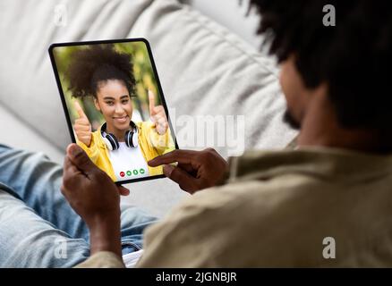Young Black Man Using Digital Tablet For Video Call At Home Stock Photo