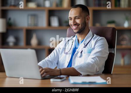Handsome middle eastern doctor working on computer at clinic Stock Photo