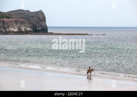 Around the UK - Single horse rider on Sandsend Bay, , North Yorkshire, UK Stock Photo