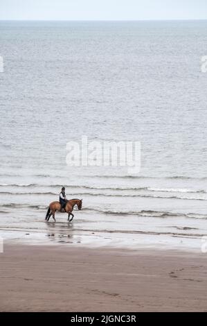 Around the UK - Single horse rider on Sandsend Bay, , North Yorkshire, UK Stock Photo