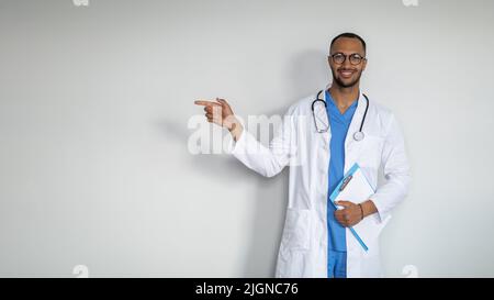 Smiling middle eastern doctor pointing at copy space Stock Photo
