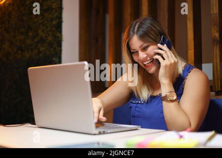 Entrepeneur woman talking on phone so happy with a laptop writing Stock Photo