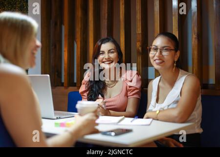 Students sitting talking at cafe as friends Stock Photo