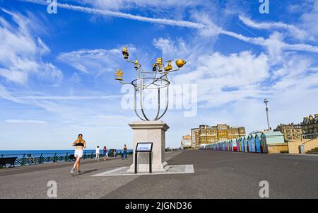 Hove , Brighton UK 12th July 2022 - Runners and walkers  are out early along Hove seafront by the plinth as the hot sunny weather continues throughout Britain with temperatures expected top reach over 30 degrees in some parts  : Credit Simon Dack / Alamy Live News Stock Photo