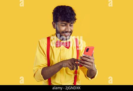 Smiling Indian man texting on cellphone Stock Photo