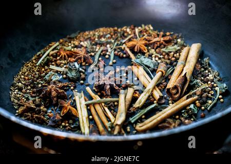 spices in a pan, A spice is a seed, fruit, root, bark, or other plant substance primarily used for flavoring or coloring food. Spices are sometimes us Stock Photo