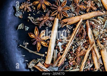 spices in a pan, A spice is a seed, fruit, root, bark, or other plant substance primarily used for flavoring or coloring food. Spices are sometimes us Stock Photo