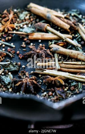 spices in a pan, A spice is a seed, fruit, root, bark, or other plant substance primarily used for flavoring or coloring food. Spices are sometimes us Stock Photo