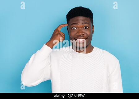 Photo of cheerful good mood male scratching his head trying to remember something isolated on blue color background Stock Photo