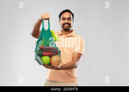happy indian man with food in reusable net tote Stock Photo