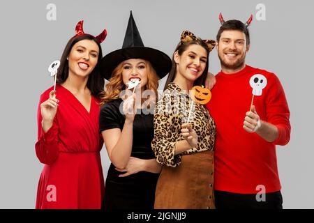 friends in halloween costumes with party props Stock Photo