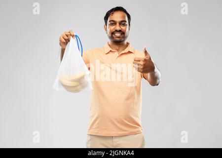 happy man holding reusable string bag with bananas Stock Photo