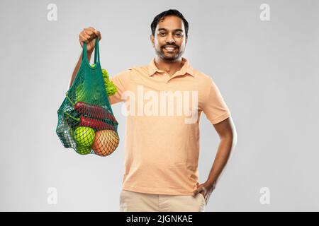 happy indian man with food in reusable net tote Stock Photo