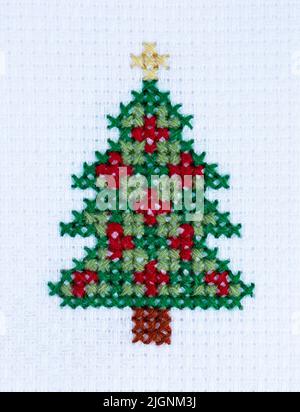Close up of a simple cross stitch pattern of a colourful Christmas Tree with copy space Stock Photo