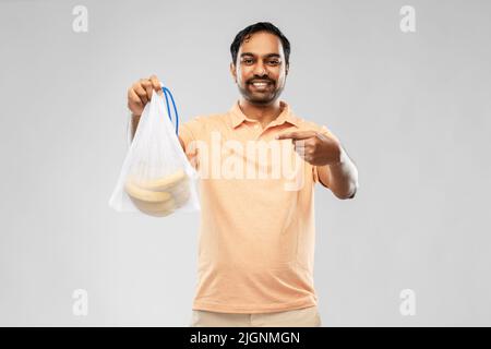 happy man holding reusable string bag with bananas Stock Photo