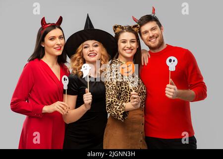 friends in halloween costumes with party props Stock Photo