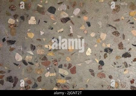 Texture of a grey cement wall with different natural little stones. Stock Photo