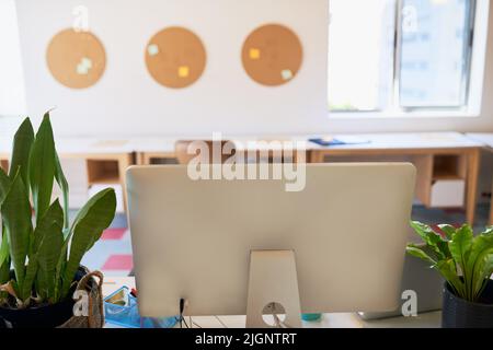 An empty creative office with big computer screen on the desk Stock Photo