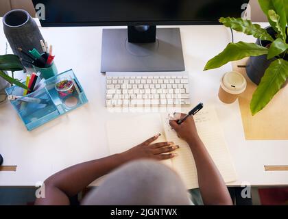 A young woman writes in her journal at a very neat desk staying organised Stock Photo