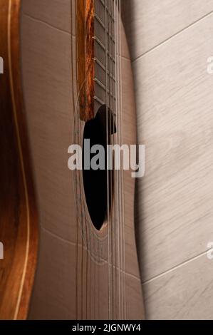 Classical guitar sound hole and strings up close on a light wood background Stock Photo