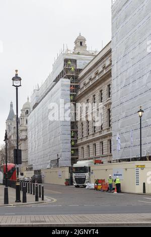 Construction workers passing poles of scaffold upwards, London, UK Stock Photo