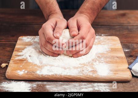 Baker holding raw dough in hands close-up Stock Photo