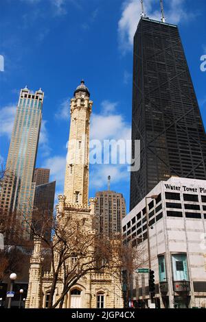 The modern John Hancock Center skyscraper contrasts with the historic stone Water Tower on Michigan Avenue in Chicago, Illinois Stock Photo