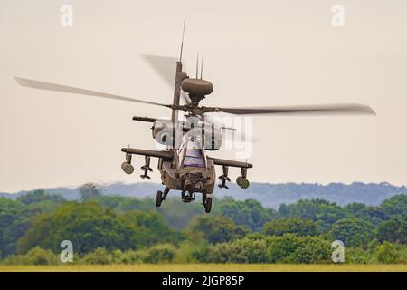 The Army Air Corps latest Apache AH-64E attack helicopter performs maneuvers over open countryside at the Army Aviation Centre at Middle Wallop, Stockbridge in Hampshire. Picture date: Tuesday July 12, 2022. Stock Photo